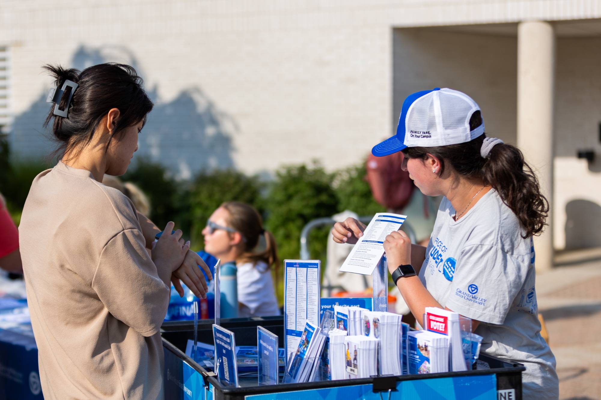 A student staff member showing another student a Student Life RSO brochure